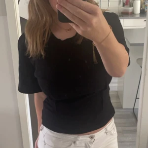 Svart topp från Carin Wester - Säljer en stilren svart topp från Carin Wester i storlek S. Toppen har korta ärmar och en klassisk rund halsringning. Perfekt för en minimalistisk look.