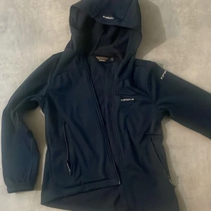 Mörkblå fleecejacka från Icepeak - Säljer en mörkblå fleecejacka från Icepeak med huva och dragkedja. Jackan har långa ärmar och praktiska fickor med dragkedja. Perfekt för kyliga dagar.