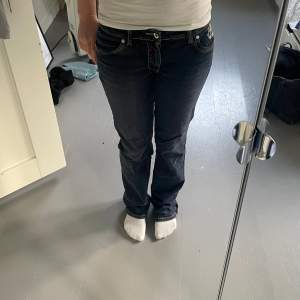 Snygga mörkblå jeans från Reminiscence med broderade detaljer på bakfickorna. De har en bootcut-stil och är tillverkade i en bomulls- och spandexblandning för extra komfort. 