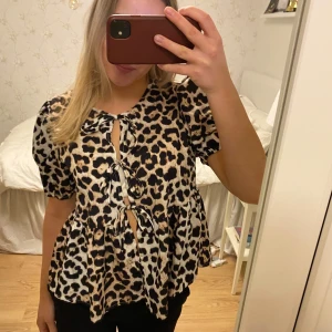 Leopardmönstrad blus med knyt - Trendig leopardmönstrad blus med puffärmar och knyt framtill. 