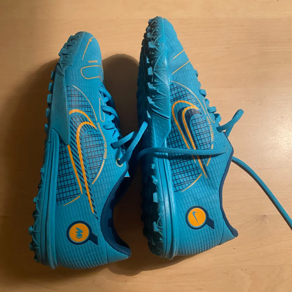 Snygga blå fotbollsskor från Nike med gula detaljer. Knappt använda och i väldigt bra skick. Dobbfria skor för spel på konstgräs. . Kengät.