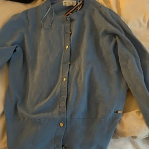 Ljusblå kofta från holly white  - Säljer en superfin ljusblå kofta från holly white i mycket bra skick. Den har långa ärmar och knappar hela vägen fram. Perfekt för vår och sommar, och den är gjord i ett mjukt bomullsmaterial. Passar både till vardags och lite finare tillfällen. 🌸