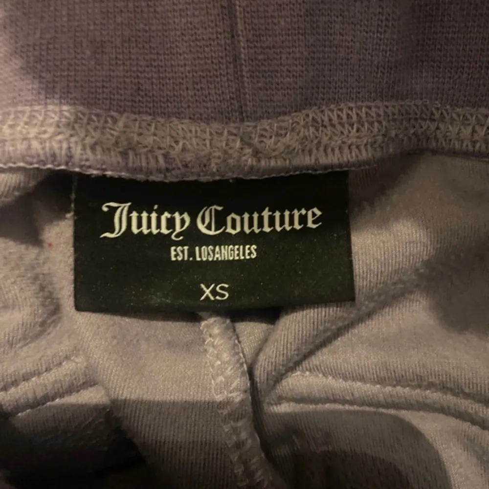 Säljer ett par supermysiga lila mjukisbyxor från Juicy Couture i storlek XS men som även passar XXS. Byxorna har en loose passform och är gjorda i mjuk velour med snörning i midjan. Perfekta för en chill dag hemma eller en avslappnad utflykt. De har också en praktisk ficka bak. . Jeans & Byxor.