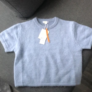 Ljusblå stickad tröja från Gina Tricot - Säljer en superfin ljusblå stickad tröja från Gina Tricot. Den är i nytt skick och perfekt för både vår och höst. Tröjan har en normal passform och korta ärmar, vilket gör den både bekväm och stilren. Perfekt att matcha med jeans eller kjol för en avslappnad look.