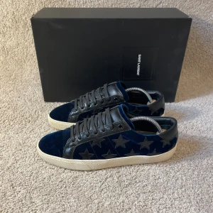 Saint Laurent skor  - Mörkblåa saint Laurent skor i velvour material, men svarta stjärnor. Storlek 40,5 men passar bra upp till 41-41,5. Box, skopåse & kort ingår.