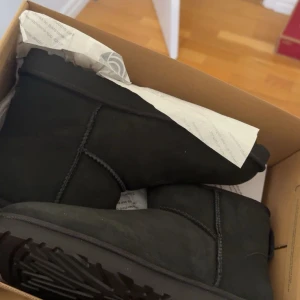 Svarta uggs  - Säljer mina mens Uggs mini i svart! Köpte dessa i USA i stress och fick storleken fel… De är använda högst 3 gånger i torrt väder. Ser i princip helt nya ut. Perfekt för kalla dagar nu i höst och vinter. 