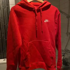 Säljer en snygg röd hoodie från Nike i storlek XS. Den är i bra skick och perfekt för både höst och vinter. Hoodien har en klassisk design med en stor ficka fram och Nike-loggan på bröstet. Perfekt för en casual look eller träning! 🔥