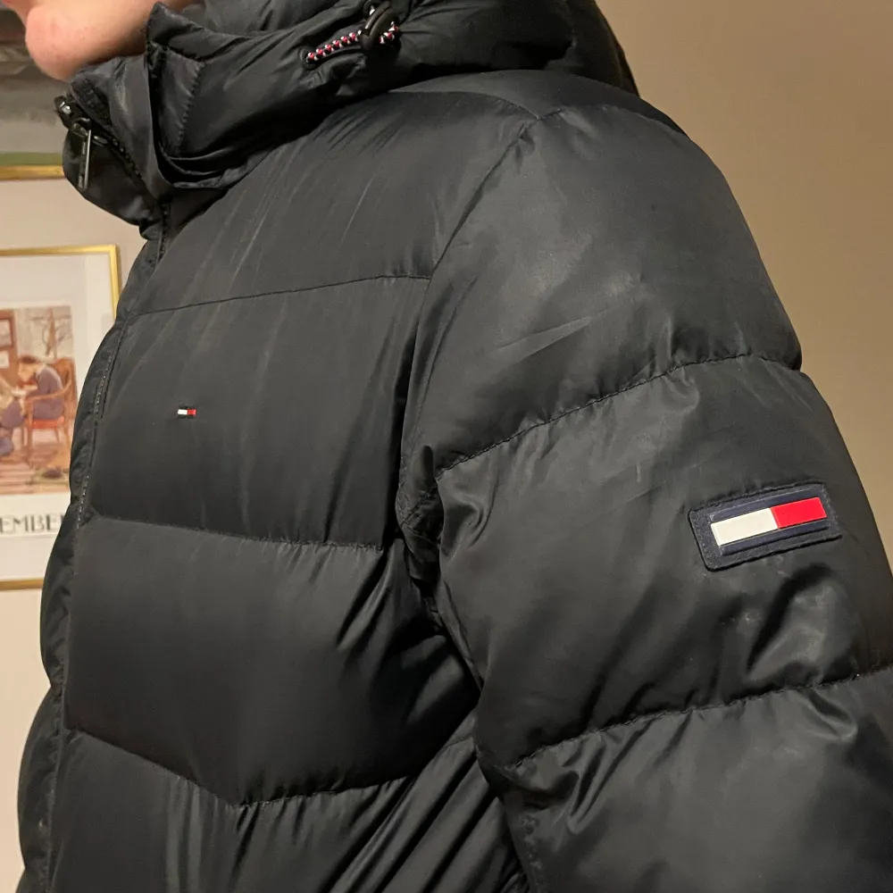 Säljer en svart pufferjacka från Tommy Hilfiger i bra skick. Den har märkets logga på bröstet och ärmen. Strl M. Superbekväm och varm!. Jackor.