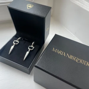 Maria Nilsdotter örhängen - Väldigt sparsamt använda örhängen från Maria Nilsdotter. Köpta i våras och använda bara någon enstaka gång. Kommer med orginalbox. Nypris: 4595kr 