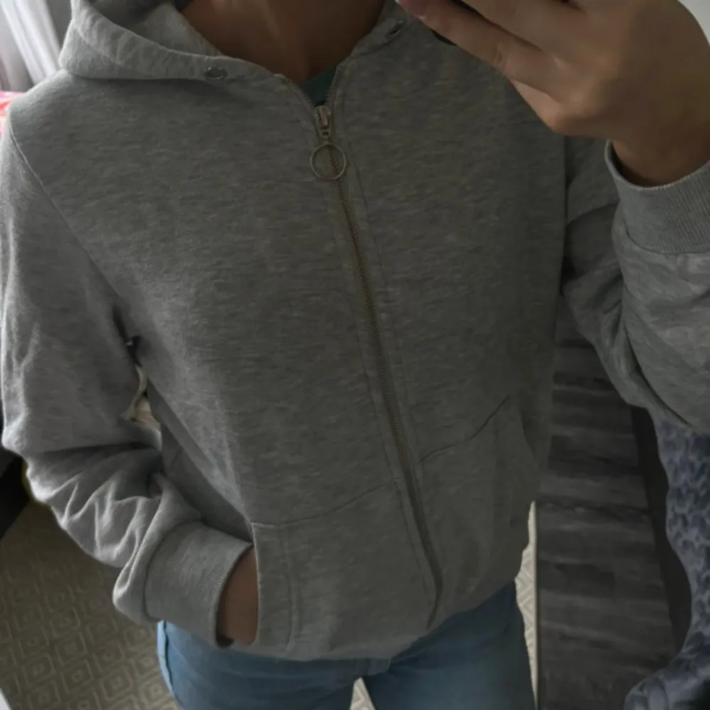 Säljer en grå hoodie i mycket bra skick. Den har en dragkedja framtill och en mysig huva. Perfekt för höst och vår, och passar till alla casual outfits. Storleken är normal och materialet känns mjukt och bekvämt. . Tröjor & Koftor.