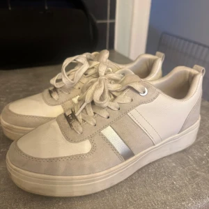 Vita och grå sneakers med snörning - Säljer ett par snygga vita och grå sneakers i mycket bra skick. Perfekta för både vardag och fest! Skorna är sköna att gå i och passar till de flesta outfits. Inköpta för 899 och använda kanske fem gånger max 