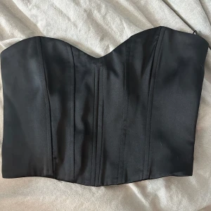 Svart korsett från Zara - Snygg svart korsett från Zara i storlek XS. Den har en stilren design med en smickrande passform och dragkedja på sidan. Perfekt för en utekväll eller fest! 🖤