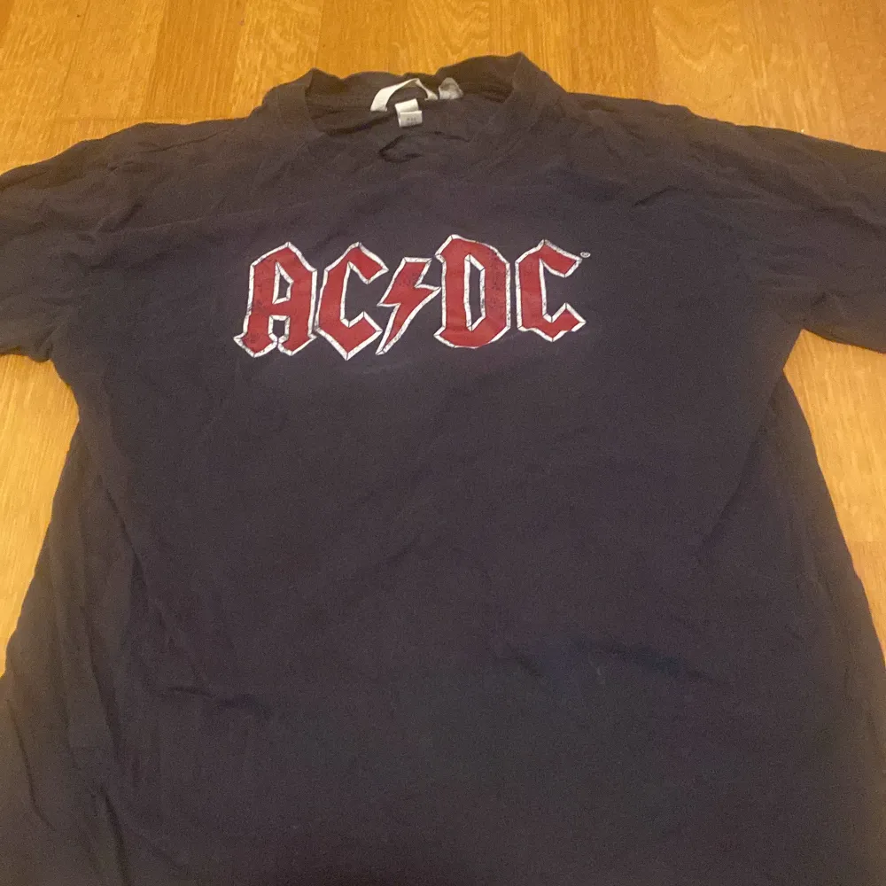 Cool svart AC/DC t-shirt med tryck från 'Back in Black World Tour 1980/81'. Perfekt för rockälskare! T-shirten har korta ärmar och är i bra skick. Passar perfekt till vardags eller konsert.. T-shirts.