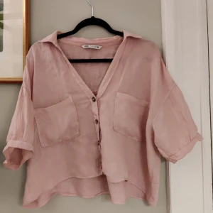 Rosa linne blus från Zara - Säljer en superfin rosa linne-blus från Zara i storlek L. Den har en avslappnad passform med trekvartsärmar och knappar framtill. Perfekt för vår och sommar! 💖