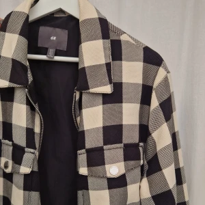 L | Rutig Höstjacka H&M - Rutig höstjacka från H&M storlek L. Bra skick. Lite fransig på ena bröstfickan. Liten fläck som förmodligen går bort.