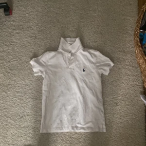Vit pikétröja från Polo - Säljer en klassisk vit pikétröja från Polo. Den har korta ärmar och en liten broderad logga på bröstet. Perfekt för en stilren och avslappnad look. Tröjan är i bra skick och passar till både vardag och fest. Skicka ett meddelande vid intresse!