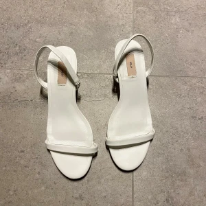 Vita klackar - Säljer dessa vita klackar från Nelly i storlek 36. Har endast använt dem en gång. De är i bra skick. 5 cm klack. Nypris 299, säljer de för 159