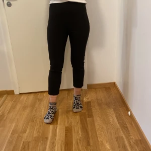 Svarta kostymbyxor från Zara - Säljer ett par stilrena svarta kostymbyxor från Zara i storlek S. De är högmidjade och har en klassisk rak passform som passar perfekt för både kontoret och festliga tillfällen. Byxorna är tillverkade i ett bekvämt material som ger en snygg siluett. Perfekta för höst och vinter!