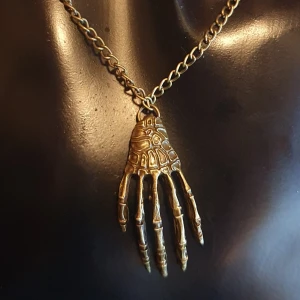 Halsband - Skeletthand - Halsband Skelett oanvänd, kedjan är i antikguld och mått är ca 70 cm, och hänget är 3.5 cm. ✨️✨️✨️Titta igenom alla mina upplagda och köp fler saker i bundle för att spara på frakten och få allt du köpt i ett och samma paket✨️✨️✨️