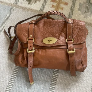 Mulberry Alexa (med kvitto!) - Äkta Mulberry Alexa, fint skick, mkt diskret slitage enligt bild. Perfekt som datorväska. Dustbag. Originalkvitto kan uppvisas (viktigt då denna modell plagierats mkt!) Denna vara skickas rekommenderat, lite högre fraktkostnad.