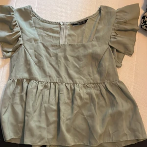 Grön topp från SHEIN - Säljer en söt grön topp från SHEIN i storlek S. Den har korta puffärmar och en fyrkantig urringning. Perfekt för vår och sommar! 🌿