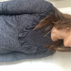 Grå/Svart tröja med Volanger - Säljer denna fina Volang tröja från CLUB XPRS Stl XS💞säljer då den inte kommer till användning för endast 150 kr✨skriv för fler frågor!