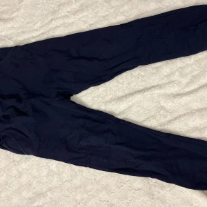 Marinblå byxor - Säljer ett par marinblå byxor i storlek 160. De är i bra skick och perfekta för vardagsbruk. Byxorna har en enkel design och är bekväma att bära. Passar till både avslappnade och mer uppklädda tillfällen.