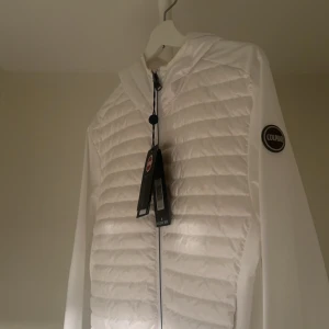 En helt ny colmar jacka  - En Colmar jacka som är känd för sin design och hållbarhet. Den vita färgen ger den en fräsch och modern look som passar bra i olika sammanhang. Denna helt nya jacka passar in i alla tillfällen.