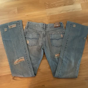 Ljusblå bootcutjeans - Supersnygga ljusblå, lowwaist, bootcut jeans med hål. Storlek 25, nyskick Priset kan diskuteras