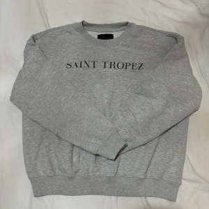 Grå hoodie - En grå hoodie med ett tryck på 