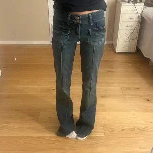Blå jeans med bootcut - Säljer ett par snygga blå jeans med bootcut-stil. De har en låg midja och coola fickdetaljer fram. Helt oanvända, säljer pga att de är för långa