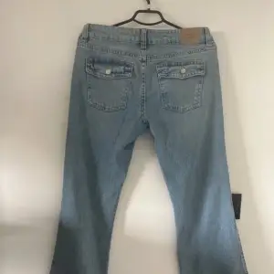 Säljer ett par Lågmidjade  ljusblå jeans från GinaTricot. Det finns fickor med knappar och dragkedja fram. De är i mycket bra skick. Inga defekter alls. Strl40. Nypris 499kr