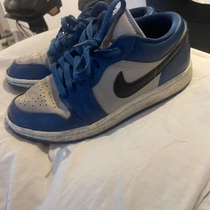 Nike Air Jordans i blått och grått - Säljer ett par Nike Air Jordans i blått och grått. Skorna har en klassisk design med snörning och en svart Nike-logga på sidan. De är i bra skick med lite slitage på sulan. Perfekta för både vardag och träning!