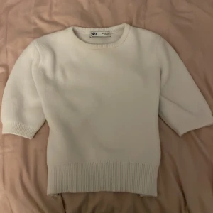 Vit tröja från Zara - Säljer en superfin vit tröja från Zara i storlek M. Den är i bra skick och har en enkel, stilren design med trekvartsärmar och ribbade kanter. Perfekt för både vår och höst! Passar till både jeans och kjol för en casual look.