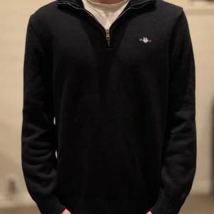 Svart tröja med dragkedja från GANT - (Tröjan är i M men passar S också!!)                 Säljer en stilren svart tröja från GANT i mycket bra skick.(knappast använd!) Den är perfekt nu inför vintern med ett sjukt snyggt mönster💯säljs för den är för liten! Skriv till mig för minsta lilla intresse eller fundering💯.                     Orginal pris: 1000kr, mitt pris: 549kr!🙌
