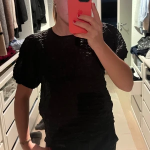 Svart topp med puffärmar - Säljer en elegant svart topp med puffiga kortärmar. Perfekt för en kväll ute eller en fest. Passar bra till både jeans och kjol.