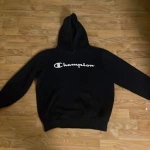 Säljer en klassisk svart hoodie från Champion med deras ikoniska logga i vitt på bröstet. Perfekt för en avslappnad stil och passar till alla tillfällen. Den är i bra skick och superbekväm att ha på sig. Perfekt för höst och vinter!