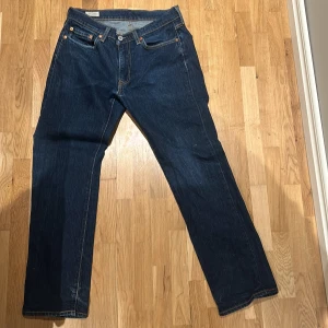 Levis 511 jeans i mörkblå denim - Säljer ett par klassiska Levis 514 jeans i mörkblå denim. De har en normal passform och är i mycket bra skick. Perfekta för både vardag och fest. Jeansens tidlösa design gör dem till ett måste i garderoben!