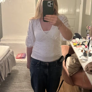 Vit omlottopp från Kappahl - Säljer en superfin vit omlottopp från Kappahl i storlek M. Toppen har trekvartsärmar och ett diskret broderat mönster. 💫