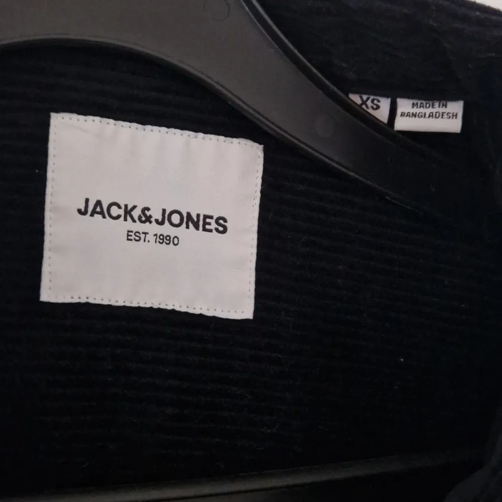 Säljer en snygg svart manchesterskjorta från Jack & Jones i storlek XS. Knappar framtill samt två bröstfickor med knappar. Perfekt för höst och vår! 🖤. Skjortor.