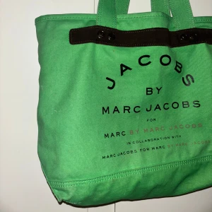 Marc by marc Jacobs väska  - Originalmodellen av Marc Jacobs iconic tote bag i årets färg – brat green 🍏  Ok skick utöver fläckar inuti och lite på baksidan samt slitet vid handtag (se bilder).  Har inte försökt tvätta bort så vet inte om det är möjligt.