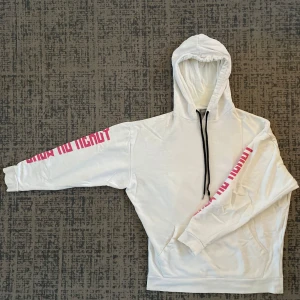 Vit hoodie från ASOS - Säljer en vit hoodie från ASOS i storlek XS. Den har coola rosa tryck på ärmarna och en klassisk känguruficka framtill. Perfekt för en avslappnad stil eller att mysa i hemma. Huvan har svarta snören för justering. Passar perfekt till höst och vår!