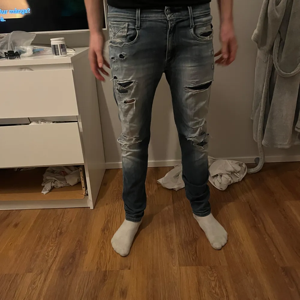 Säljer ett par snygga blå jeans med slitningar för en cool look. De har en slim passform och är perfekta för både vardag och fest. Modellen är 182 o väger 72 och dem är  i bra skick. Perfekta för dig som vill ha en avslappnad men stilren stil.. Jeans & Byxor.