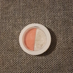 Hilighter och blush - Snygg blush och Hilighter i samma förpackning med en persikofärgad och en silvrig nyans. Perfekt för att skapa både vardagliga och festliga looks. Kommer i en praktisk rund förpackning med genomskinligt lock.
