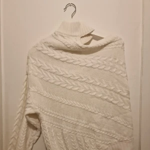 Vit stickad tröja från Therese Lindgren - Mysig vit stickad tröja från bloggaren Therese Lindgren med flätmönster. One shoulder tröja.Tröjan är både stilren och bekväm, idealisk för höst och vinter. Garderobsrensning så kika gärna in övriga auktioner