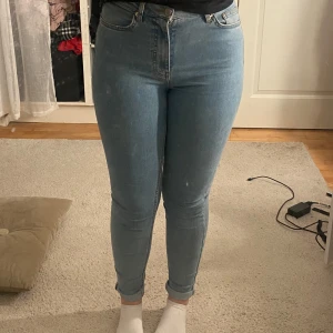 Blå skinny jeans - Säljer ett par snygga blå skinny jeans i mycket bra skick. De är högmidjade och sitter riktigt bra, perfekt för både vardag och fest. Jeansen har en klassisk femficksdesign och stängs med dragkedja och knapp. Superbekväma och stretchiga!