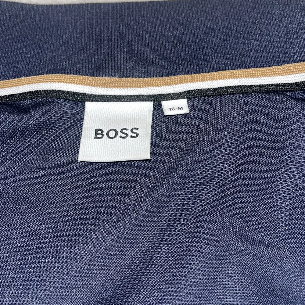 Mörk Blå kofta från Hugo BOSS i helt okej condition, inget skada/fel på den, passar bäst för dom som har höjden mellan 160-172 CM Koftan har en dragkedja framtill och vita detaljer. Perfekt för höst och vår. Passar både till vardags och lite finare tillfällen.. Hupparit & Collegepaidat.