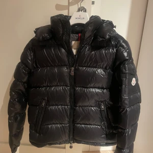 Moncler maya - Säljer en snygg svart dunjacka (Maya) från Moncler, ny skick och självklart äkta. Har fler bilder då man ser när telefonen känner av att det är moncler osv. Man får alla tillbehören till. Den är perfekt nu till vintern när det är kallt ute. Jackan är i storlek 2 och jag har vanligtvis S så passar dem som har S i vanliga fall. Men 2 motsvarar vanligtvis (M). Skriv om ni vill ha fler bilder på äktheten. Även specifika bilder på något. Kan tänka mig gå ner lite i pris vid snabb affär, inga skambud⛄️