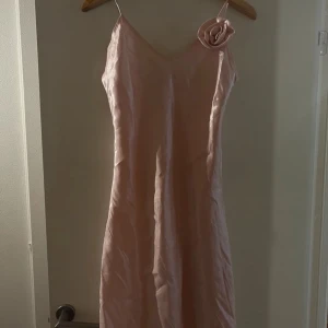 Vintage klänning - En jättefin vintage klänning i ljusrosa som är lite skimrig. En stor skarf i samma färg medföljer även. Den är i S men passar från XS-M. Den är använd fåtal gånger och är i väldigt bra skick! 