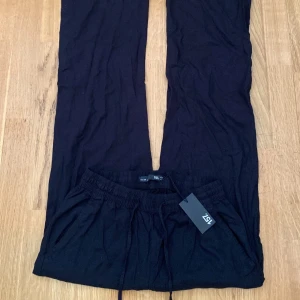 Svarta linnebyxor - Säljer ett par svarta linnebyxor som är superbekväma och perfekta för en vanlig dag eller en snabb tur till affären. De har en elastisk midja med dragsko för bästa passform. Materialet känns mjukt och skönt mot huden.